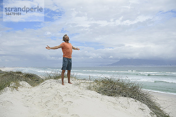 Südafrika  Mann hebt die Waffen in Bloubergstrand