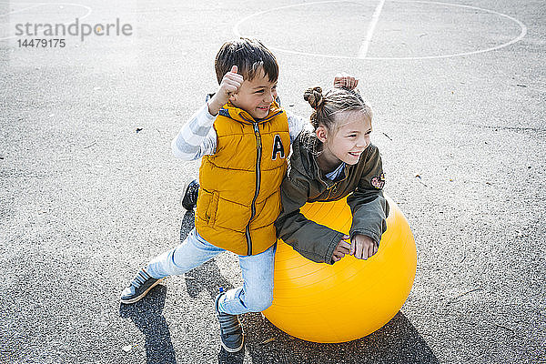 Zwei Kinder haben Spaß mit dem Gymnastikball