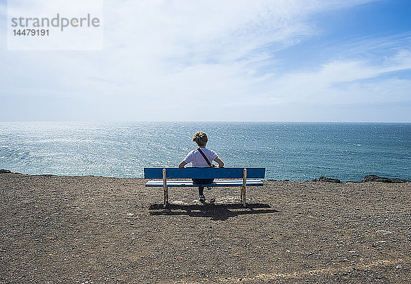 Spanien  Kanarische Inseln  Fuerteventura  Frau genießt den Sonnenschein am Strand von El Cotillo