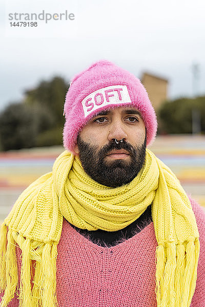 Porträt eines bärtigen Schwulen mit Nasenpiercing und rosa Mütze mit dem Wort weich .