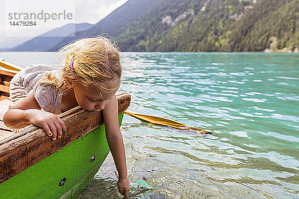 Österreich  Kärnten  Weissensee  Mädchen im Ruderboot mit der Hand im Wasser