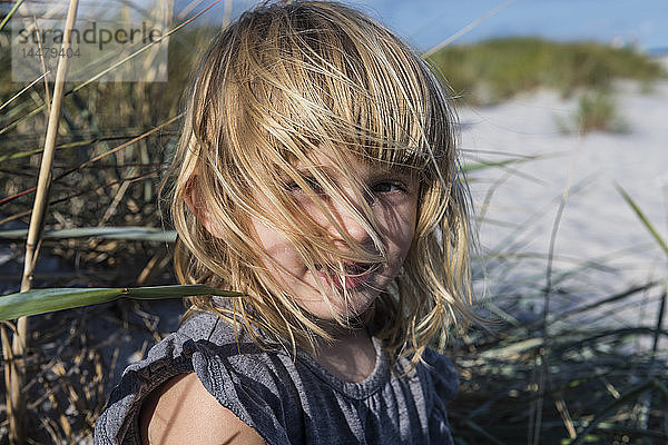Dänemark  Bornholm  Porträt eines lächelnden Mädchens am weißen Sandstrand von Dueodde