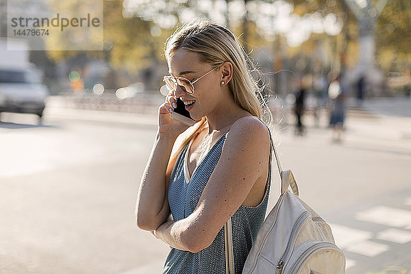Junge Frau telefoniert in der Stadt mit dem Handy