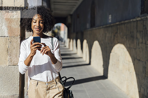 Junge Gelegenheits-Geschäftsfrau benutzt Smartpone in der Stadt