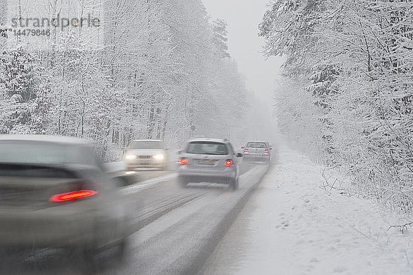 Autos fahren im Winter auf der Landstraße  es schneit