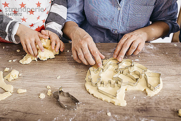 Mutter und Sohn schneiden Kekse aus  Teilansicht