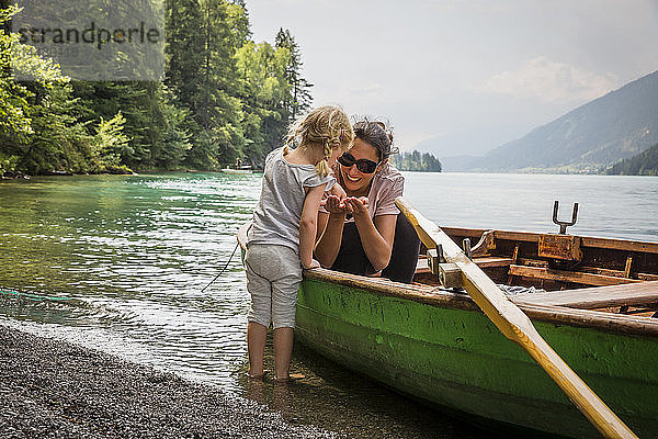 Österreich  Kärnten  Weissensee  Mutter im Ruderboot mit Tochter am Seeufer