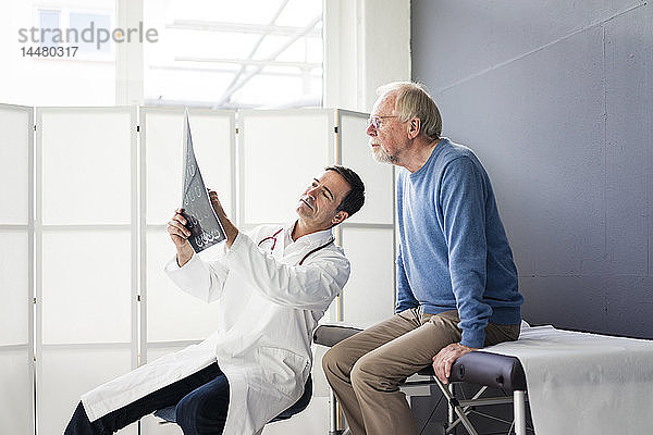 Arzt bespricht MRT-Bild mit Patient in medizinischer Praxis