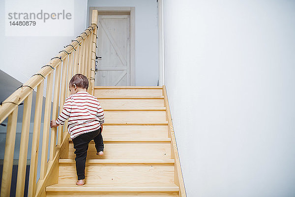 Kleinkind Junge geht zu Hause die Treppe hoch