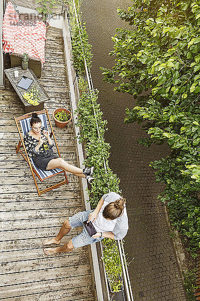 Junges Paar entspannt sich im Sommer auf ihrem Balkon