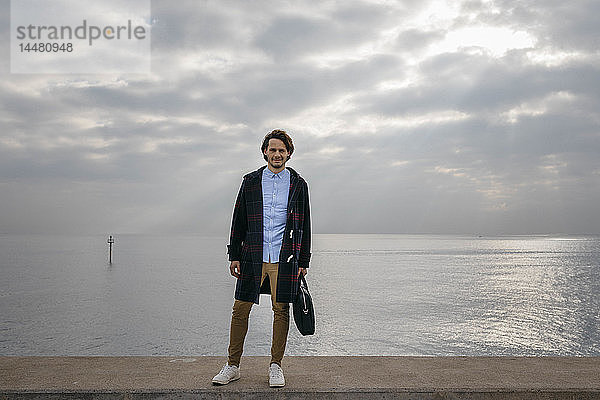 Spanien  Barcelona  Porträt eines selbstbewussten Mannes mit dem Meer im Hintergrund
