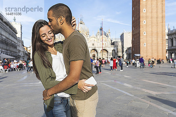 Italien  Venedig  glückliches Touristenpaar küsst sich auf dem Markusplatz