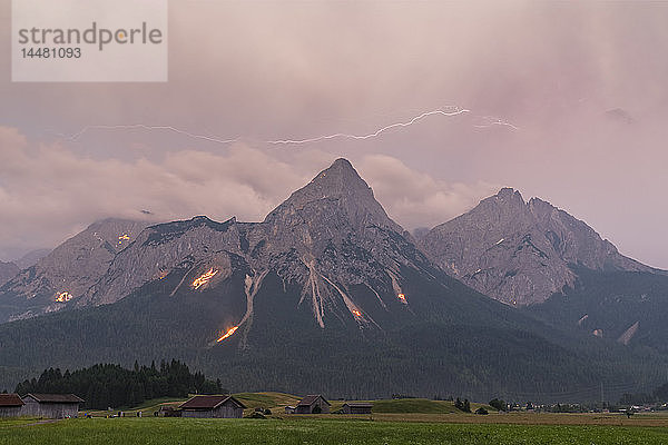 Österreich  Lermoos  Ehrwalder Becken  Ehrwalder Sonnenspitze mit Mittsommerfeuer  Gruenstein  Ehrwald  Mieminger Kette mit Gewitter und Blitz