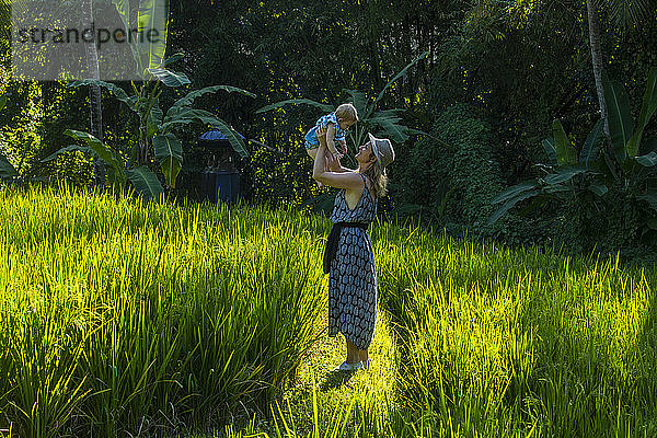 Indonesien  Bali  Ubud  Frau mit ihrem kleinen Mädchen in den Reisfeldern