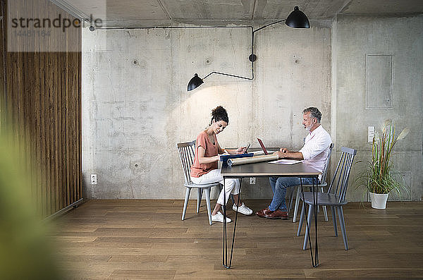 Geschäftsmann und Geschäftsfrau arbeiten am Tisch in einem Loft