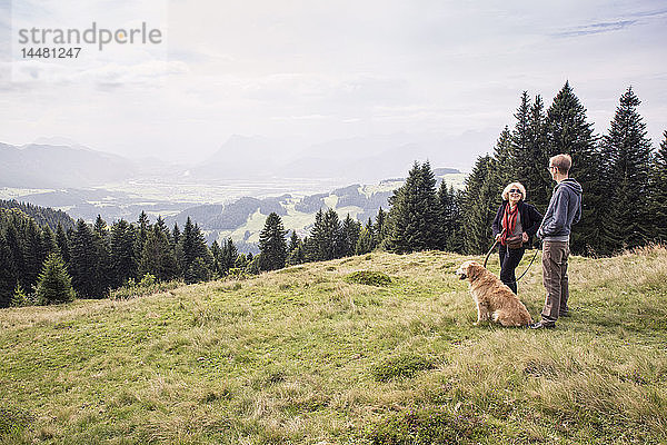 Österreich  Tirol  Kaisergebirge  Mutter und erwachsener Sohn mit Hund auf einer Wanderung in den Bergen