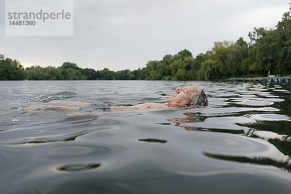 Älterer Mann schwimmt in einem See