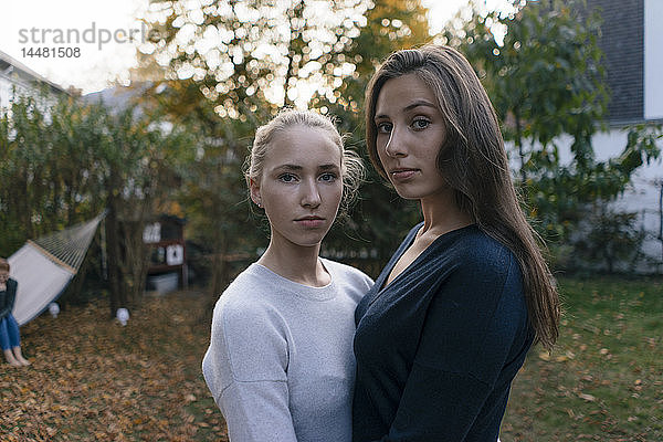Porträt von zwei ernsthaften Teenager-Mädchen im Garten