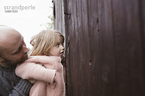 Neugieriges kleines Mädchen mit Vater