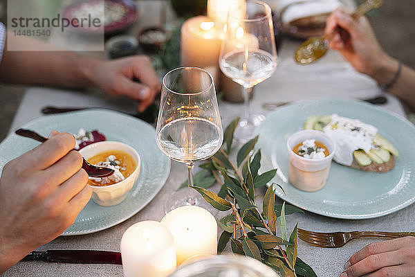 Nahaufnahme eines Paares bei einem romantischen Essen bei Kerzenlicht im Freien