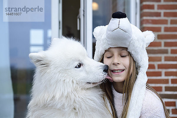 Porträt eines Mädchens auf der Terrasse mit ihrem weißen Hund