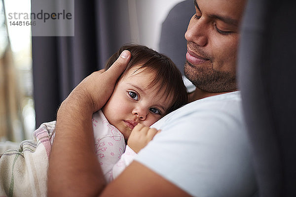 Anhänglicher Vater umarmt seine kleine Tochter zu Hause