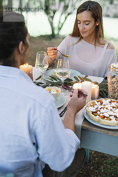 Paar beim romantischen Essen bei Kerzenlicht im Garten