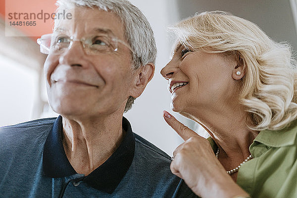 Ältere Frau spricht mit Ehemann mit Hörgerät