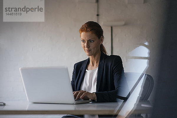 Geschäftsfrau mit Laptop am Schreibtisch im Büro