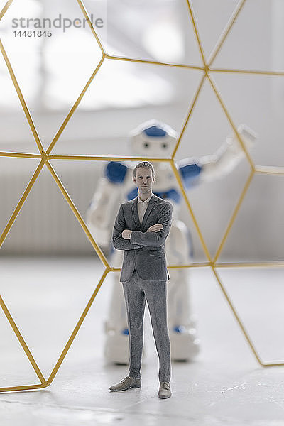 Miniatur-Geschäftsmann-Figur  die vor einem durch eine Struktur getrennten Roboter steht