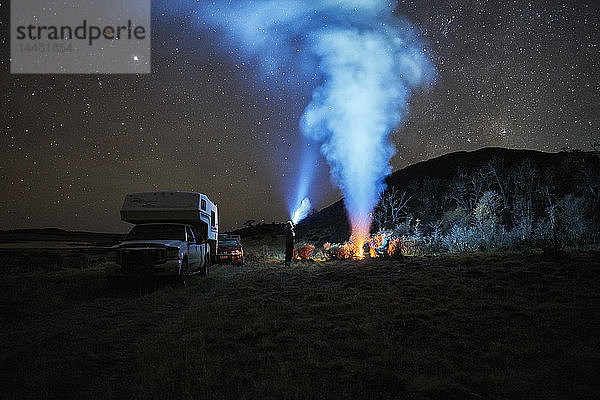 Chile  Feuerland  Lago Blanco  Lagerfeuer und Menschen im Wohnmobil unter nächtlichem Sternenhimmel