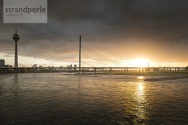 Deutschland  Düsseldorf  Oberkasselbrücke mit Medienhafen im Hintergrund in der Dämmerung