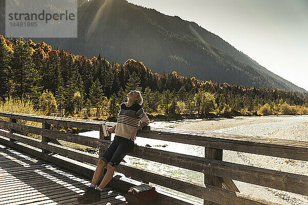 Österreich  Alpen  Frau auf einer Wanderung mit Pause auf einer Brücke
