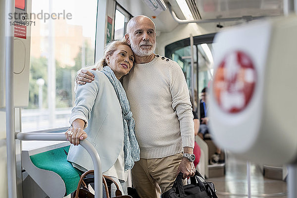 Zärtliches älteres Ehepaar steht in einer Straßenbahn