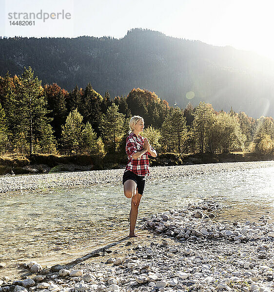 Österreich  Alpen  Yoga praktizierende Frau in einem Gebirgsbach