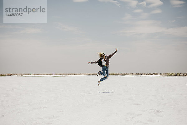 Namibia  Walvis Bay  Frau springt auf einer Salzebene