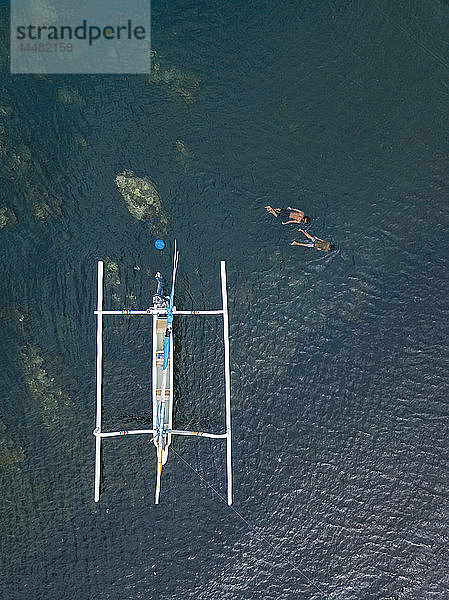 Asiatische Jungen schnorcheln im Meer  neben dem Banca-Boot