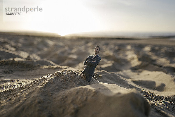 Geschäftsmann-Figur im Sand stecken geblieben