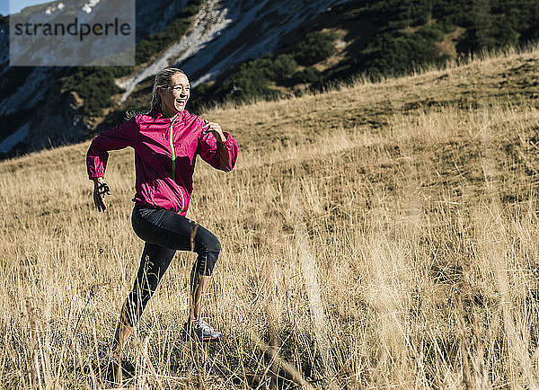 Österreich  Tirol  glückliche Frau läuft in den Bergen