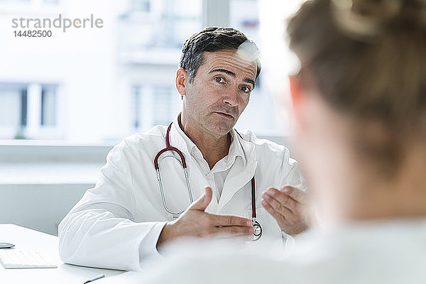Porträt eines Arztes im Gespräch mit einem Patienten in der medizinischen Praxis