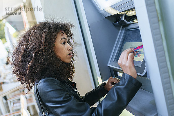 Frau benutzt Kreditkarte am Geldautomaten