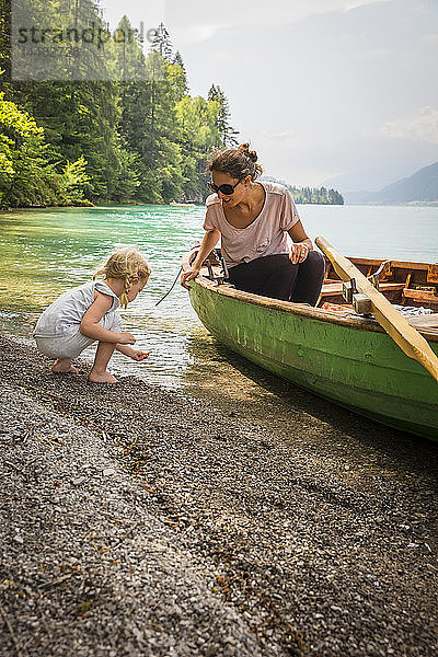 Österreich  Kärnten  Weissensee  Mutter im Ruderboot mit Tochter am Seeufer