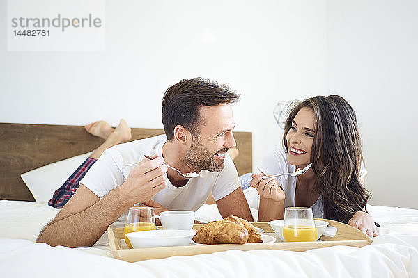 Glückliches Paar beim Frühstück im Bett