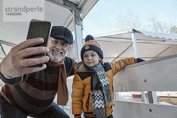 Grossvater und Enkel auf der Eisbahn  sich selbst nehmen