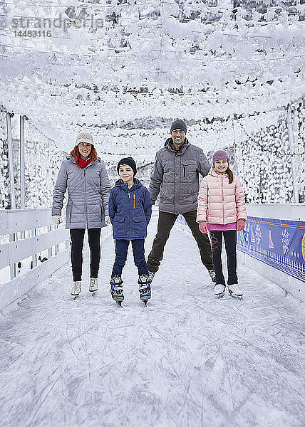 Familie mit zwei Kindern beim Schlittschuhlaufen auf der Eisbahn