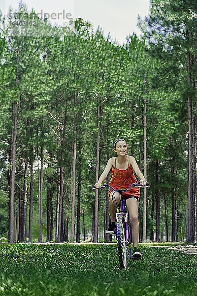 Teenager-Mädchen radelt im Wald