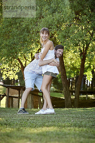 Lächelndes junges Paar im Park stehend