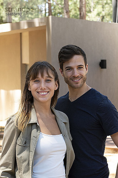 Lächelndes junges Paar steht im Freien