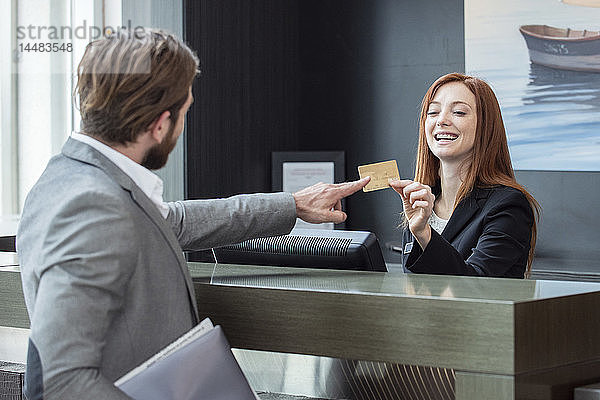 Geschäftsmann gibt Kreditkarte an Empfangsdame