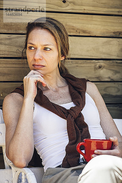 Reife Frau sitzend mit Kaffeetasse